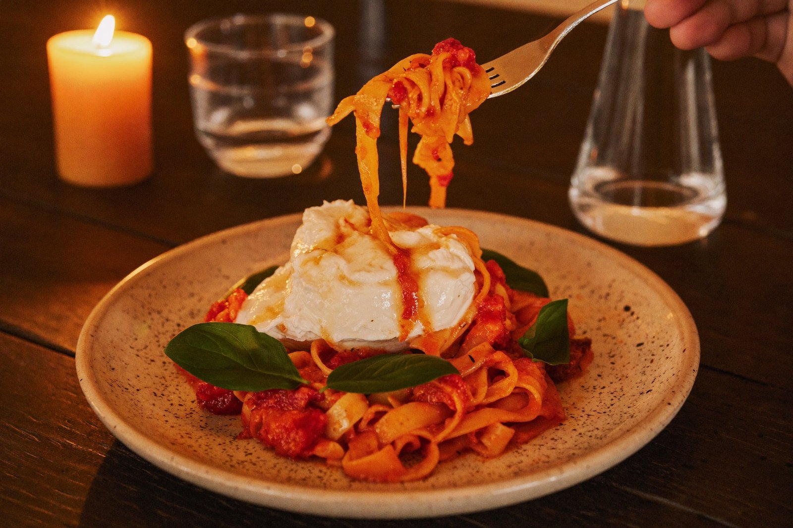 Tagliatelle mit Tomatensauce und Burrata bei Kerzenlicht
